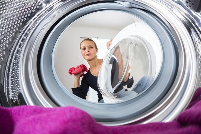 Throw a stained garment in the washer only after removing as much adhesive as possible.