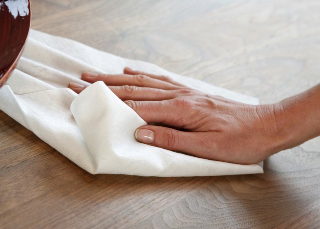 A cloth wipes wood