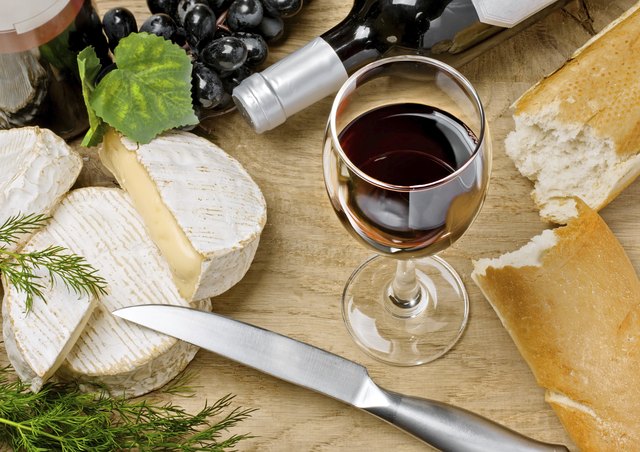 A high angle view of a glass of wine with a loaf of fresh bread.