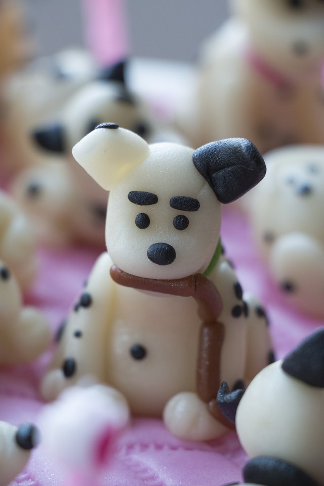 A marzipan shaped dalmation puppy with sausage in his mouth