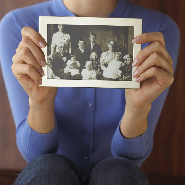 A woman holds up a photograph.