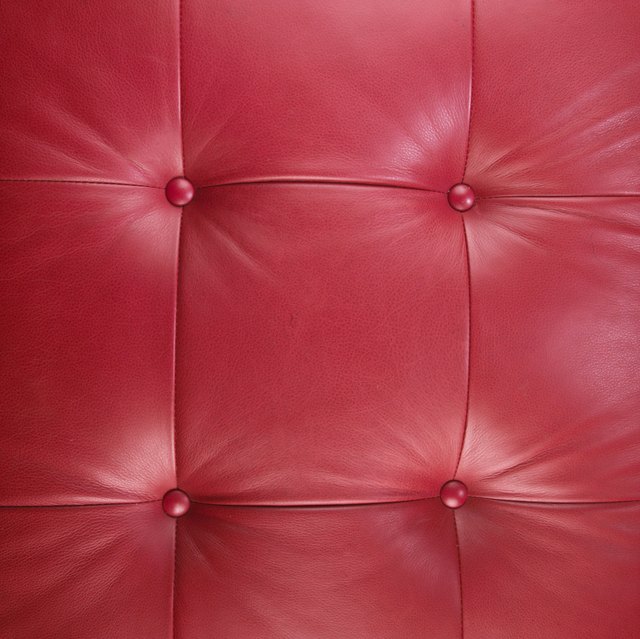 Close-up of a red leather sofa cushion.