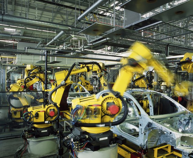 Yellow robots manufacturing cars in a factory Yellow robots manufacturing cars in a factory