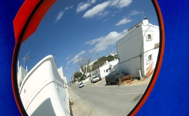 Use a convex mirror to see who is coming up the road beyond a blind turn.