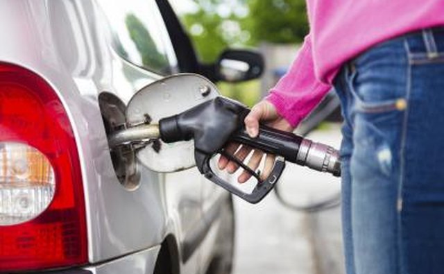 Woman filling gas tank at gas station.