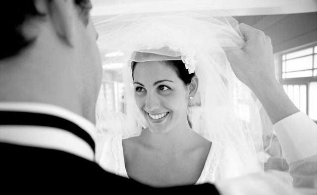 The groom lifts the veil at the end of the ceremony.