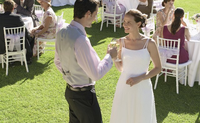 A bride and groom make a toast at their reception.