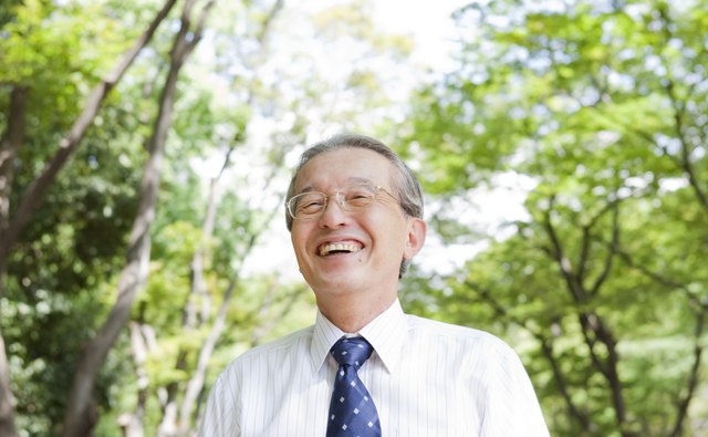 Senior businessman in park smiling