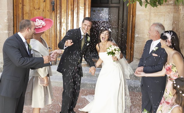 Guests throwing rice at a wedding.