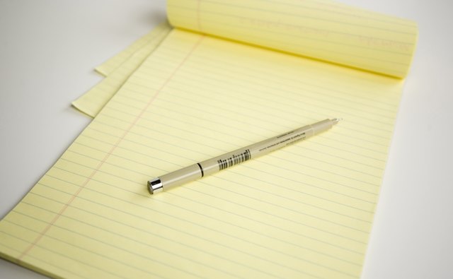 A close-up of an ink pen on a pad of paper.