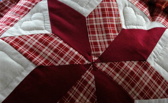 A close-up of an 8-point star stitched on an Amish quilt.