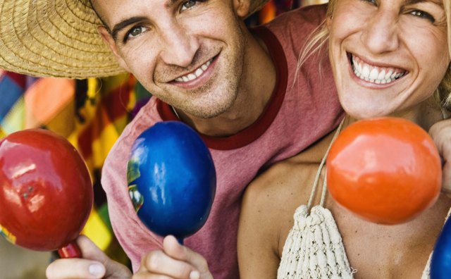 Tourists hold maracas and wear sombreros