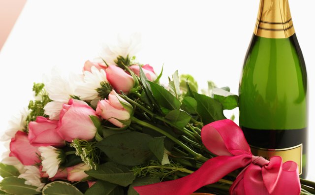 Flowers and champagne sitting on a table.