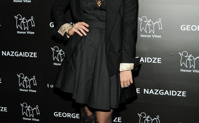 Vanessa Hudgens wears black lace tights with a black dress for a chic monochromatic look.