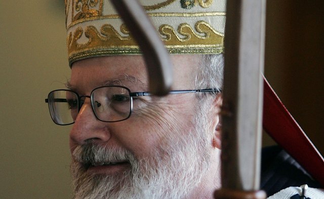 Bishop O'Malley of Massachusetts is wearing a mitre and carrying the traditional bishop's staff, the crosier.