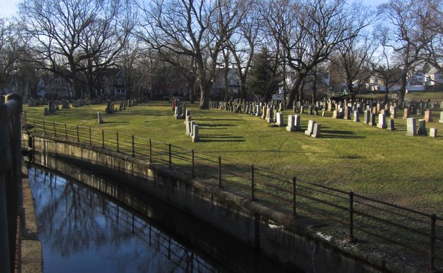 A brook runs along a cemetery.
