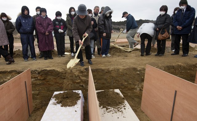 Dirt being shoveled onto coffins in China
