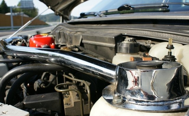 Silver gas spring behind red cannister holds up this hood.