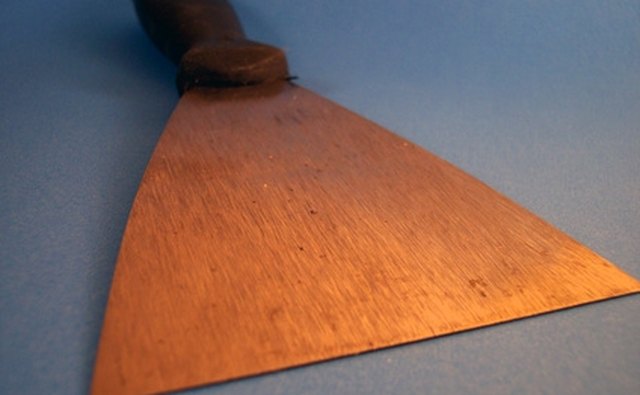 Use the flat end of the scraper.