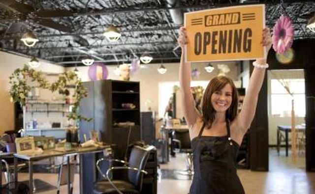 An excited salon owner holds up an open sign.