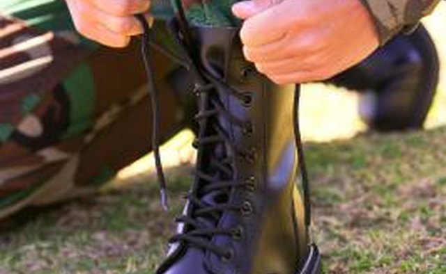 Soldier lacing up Army boot