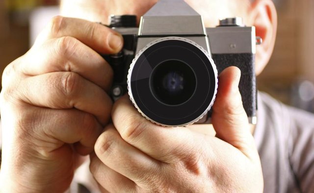 Man holding a 35 mm camera.