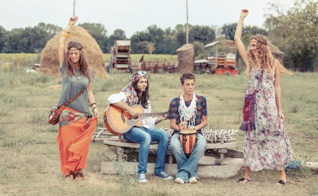 Hippies dancing and playing music in a field.