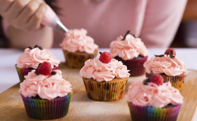 Woman icing cupcakes