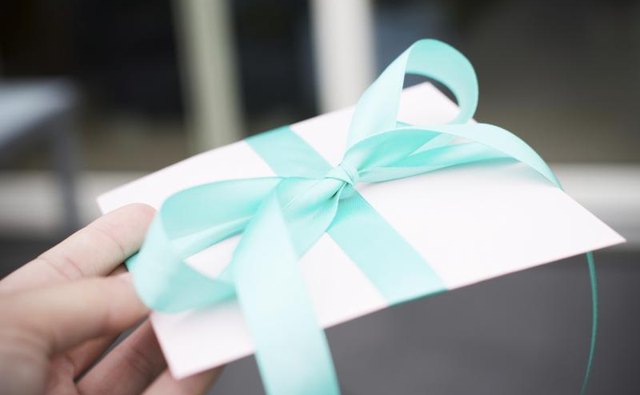 Handing over a wrapped envelope.