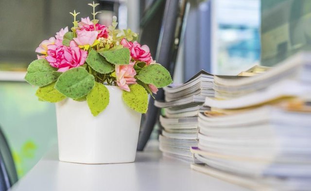 A floral arrangement sitting on a desk in the office.