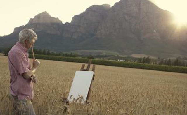 Senior man painting a landscape scene