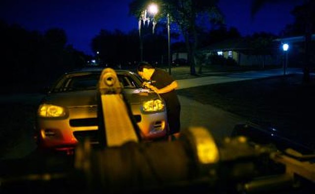 Repo man checking the VIN on a vehicle in process of being repossessed