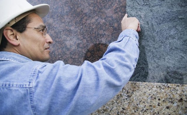 Man examining sheets of granite.