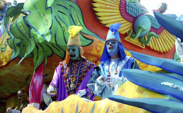 People dressed in costume on a Mardi Gras themed float.