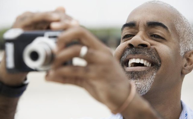 Man using a digital point and shoot camera.