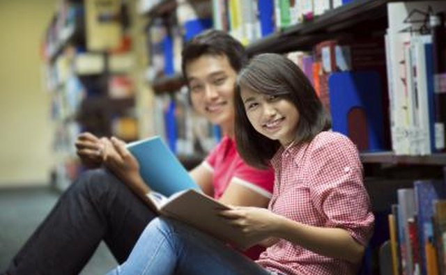 Young couple smiling at camera in library