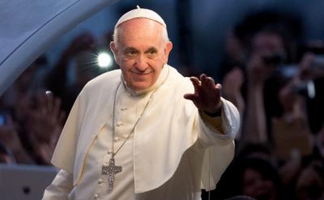 A pope greets a crowd of people.