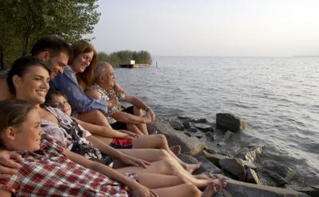 An extended family relaxes on the shoreline together.
