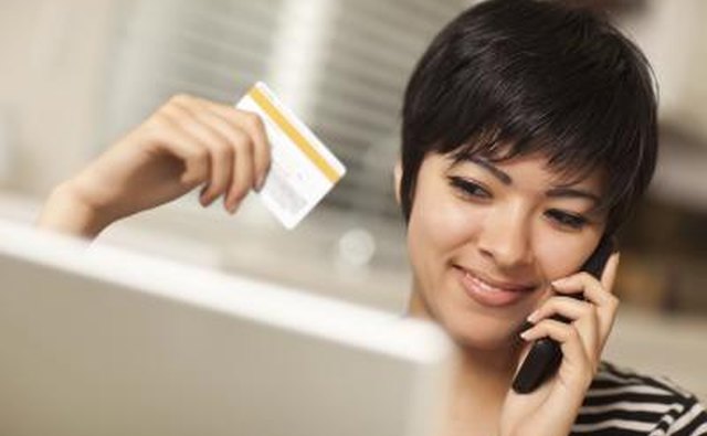Woman on telephone holding credit card