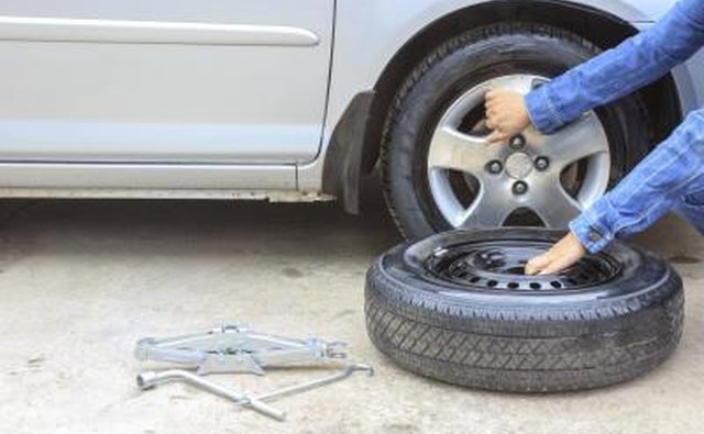 Woman removing a tire along the roadside