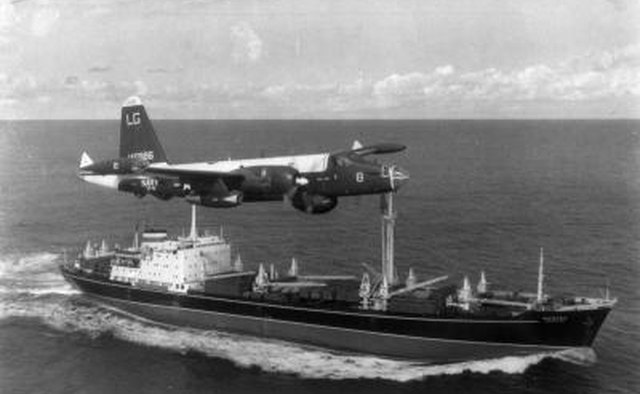 A P2V Neptune U.S. patrol plane flies over a Soviet freighter during the Cuban missile crisis in this 1962 photograph.