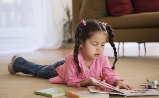 Young child reading book on floor