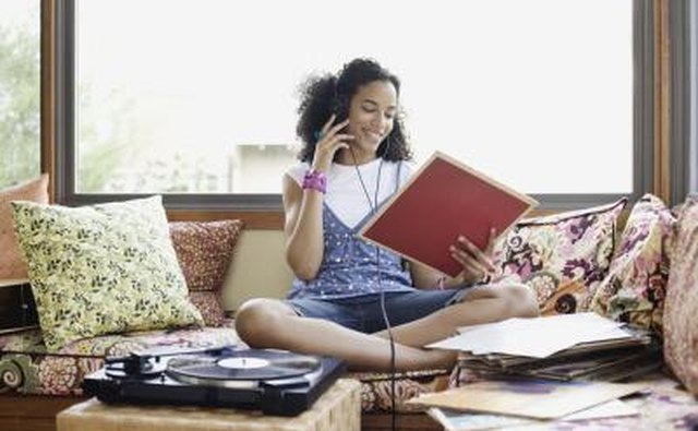 Woman listening to music on a record player.