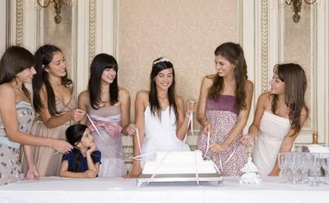 Young girls pulling ribbons from cake