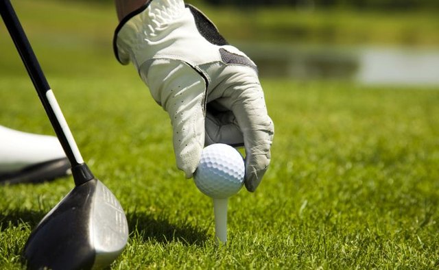Close up of golf ball and club.