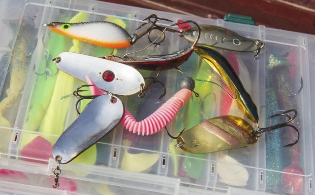 A set of fishing lures on top of a tackle box.