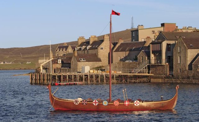 A viking boat in a small harbour.