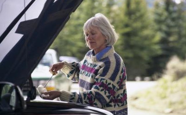 woman checking car's oil