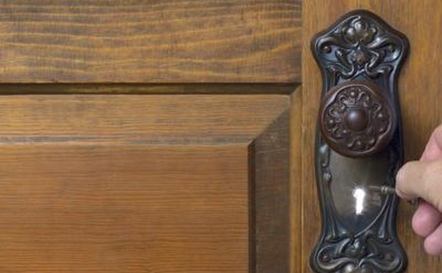 Light shines through a key hole on an ornate door fixture.