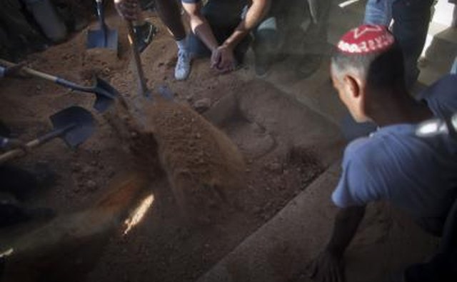 Relatives shovel dirt at funeral in Israel